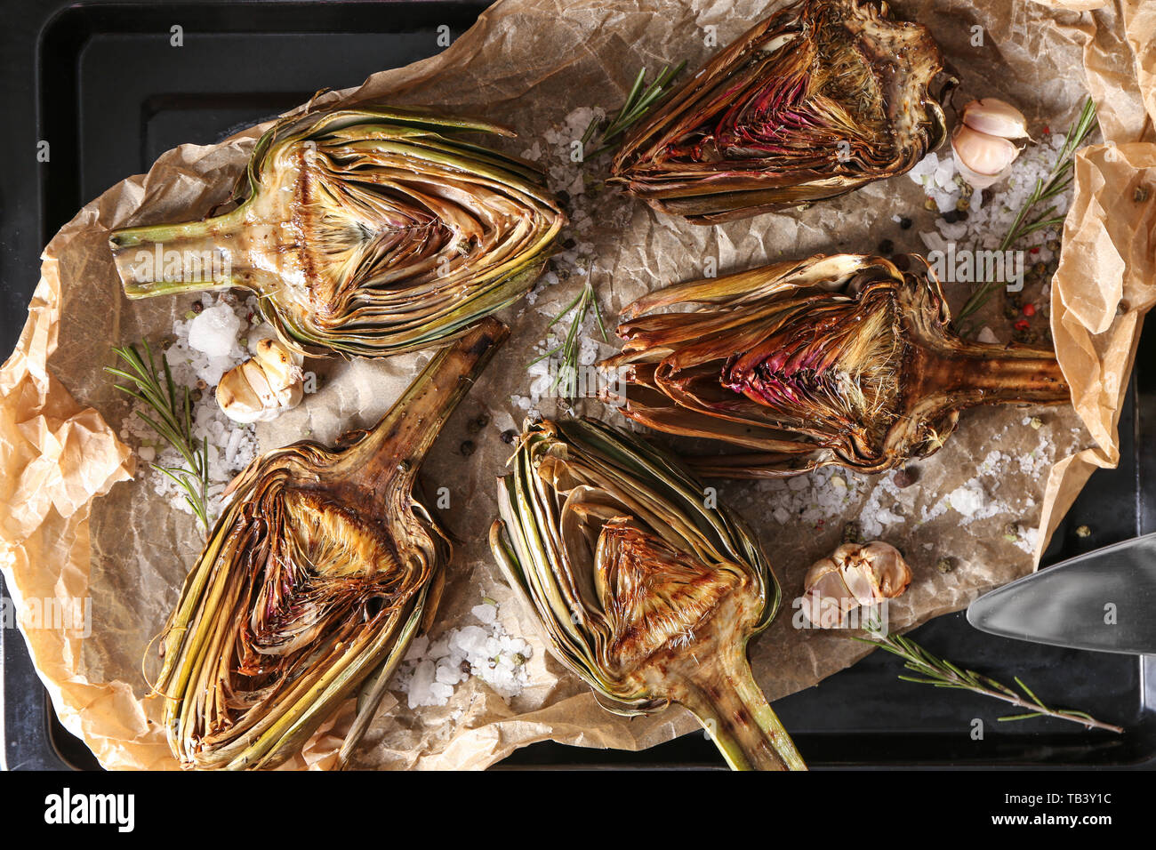 Tasty cooked artichokes on baking sheet Stock Photo