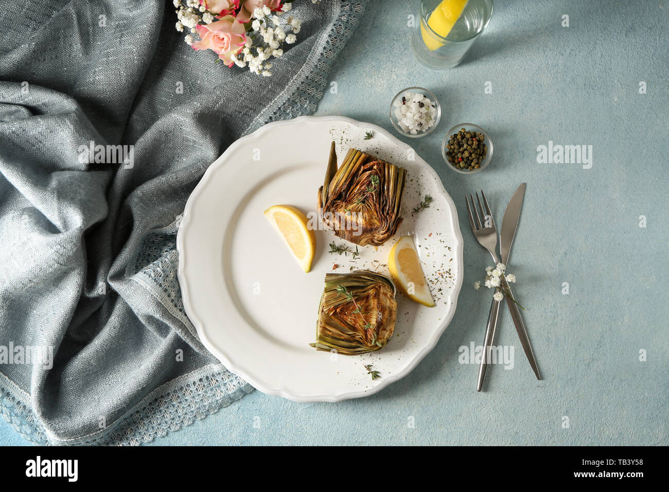 Plate with tasty grilled artichoke on table Stock Photo