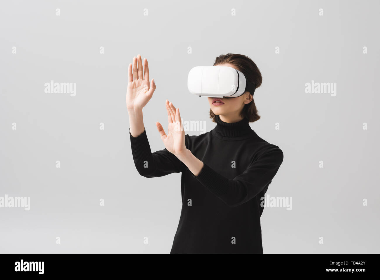 brunette young woman wearing virtual reality headset while gesturing ...