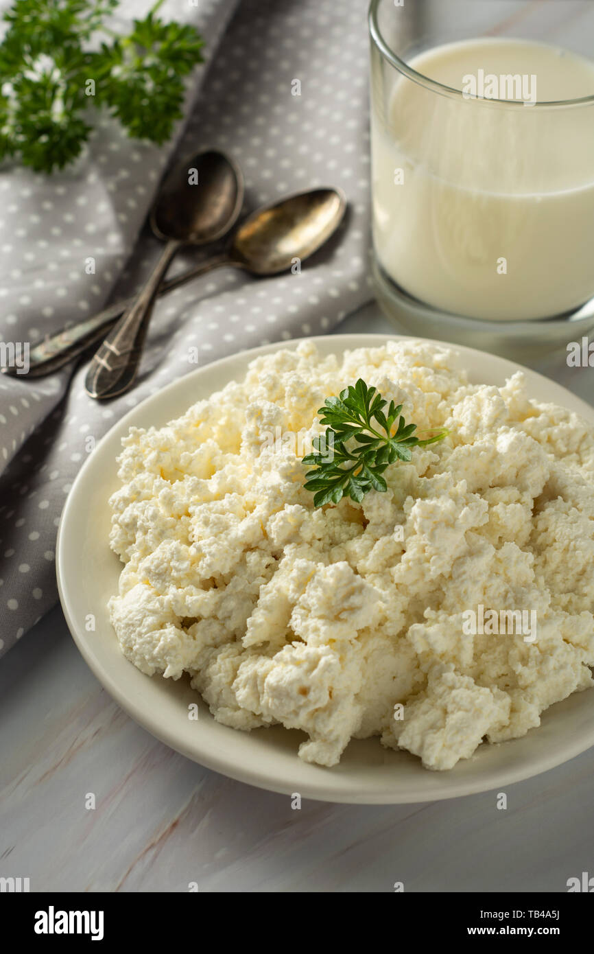 Cottage cheese isoalted on light, marble background. Dairy products