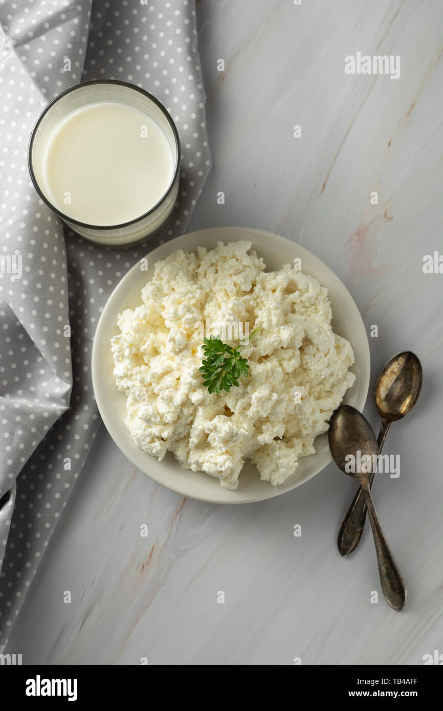 Cottage cheese isoalted on light, marble background. Dairy products