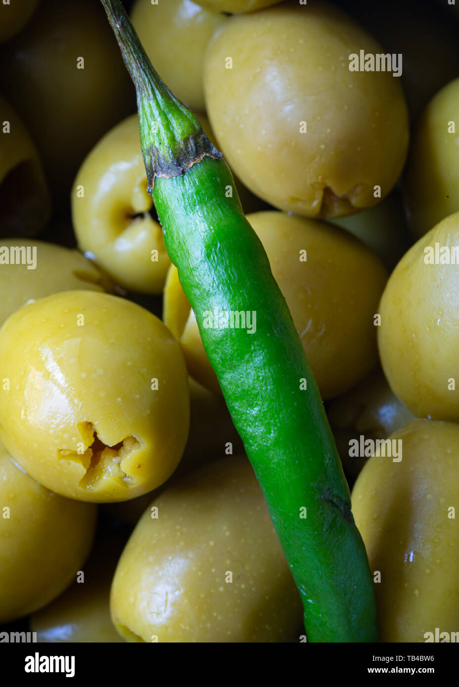 green chilli on green olives macro photo, food photo close up Stock Photo