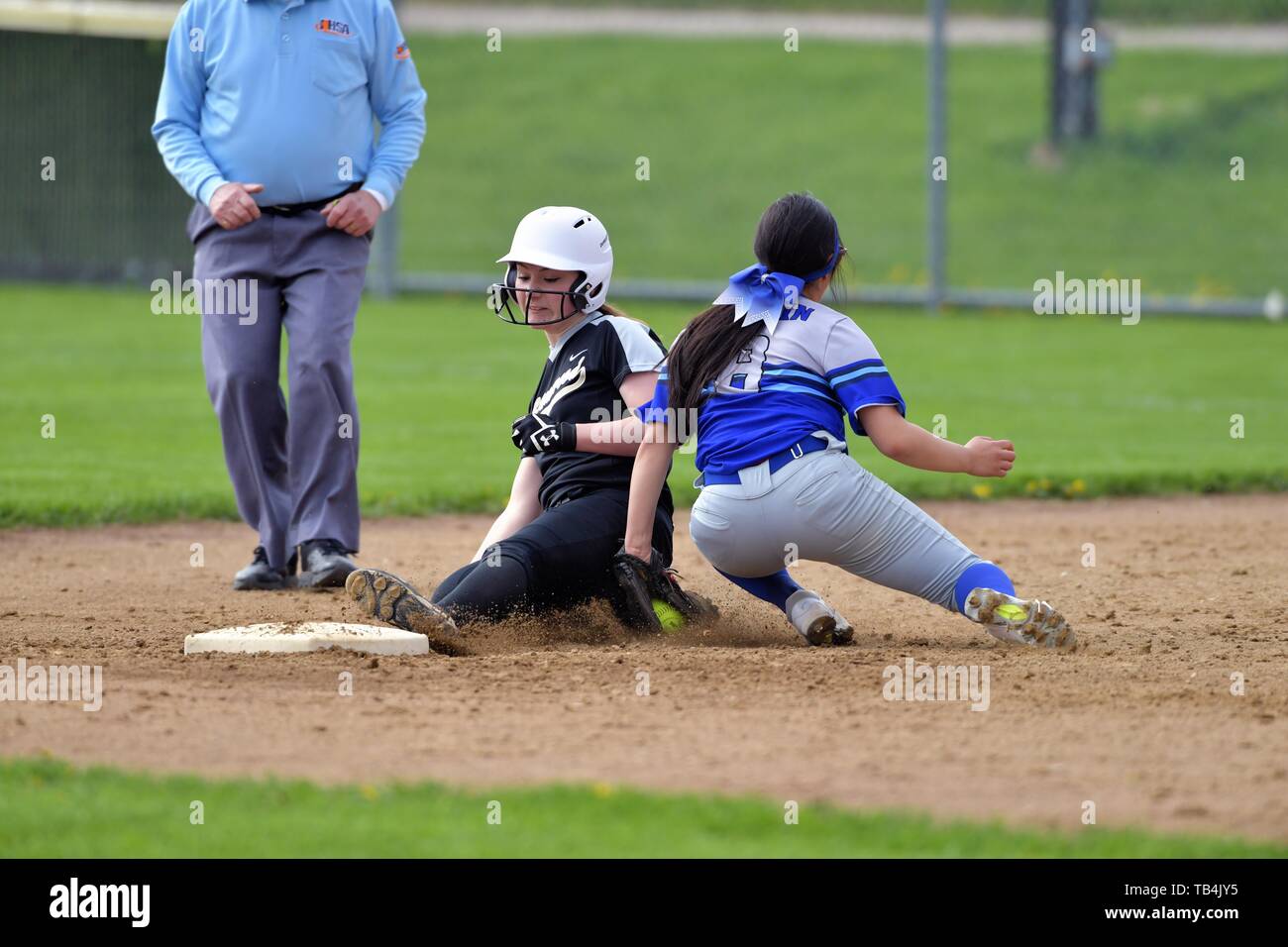 Shortstop tagging an opposing base runner out on an ill-fated steal attempt of second base. USA. Stock Photo