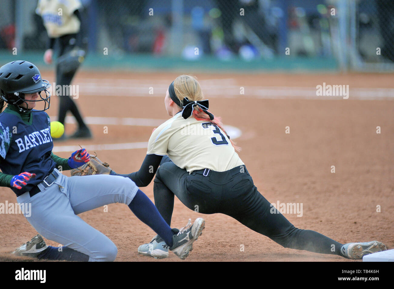 Third baseman stretching to take a throw in an effort to retire a