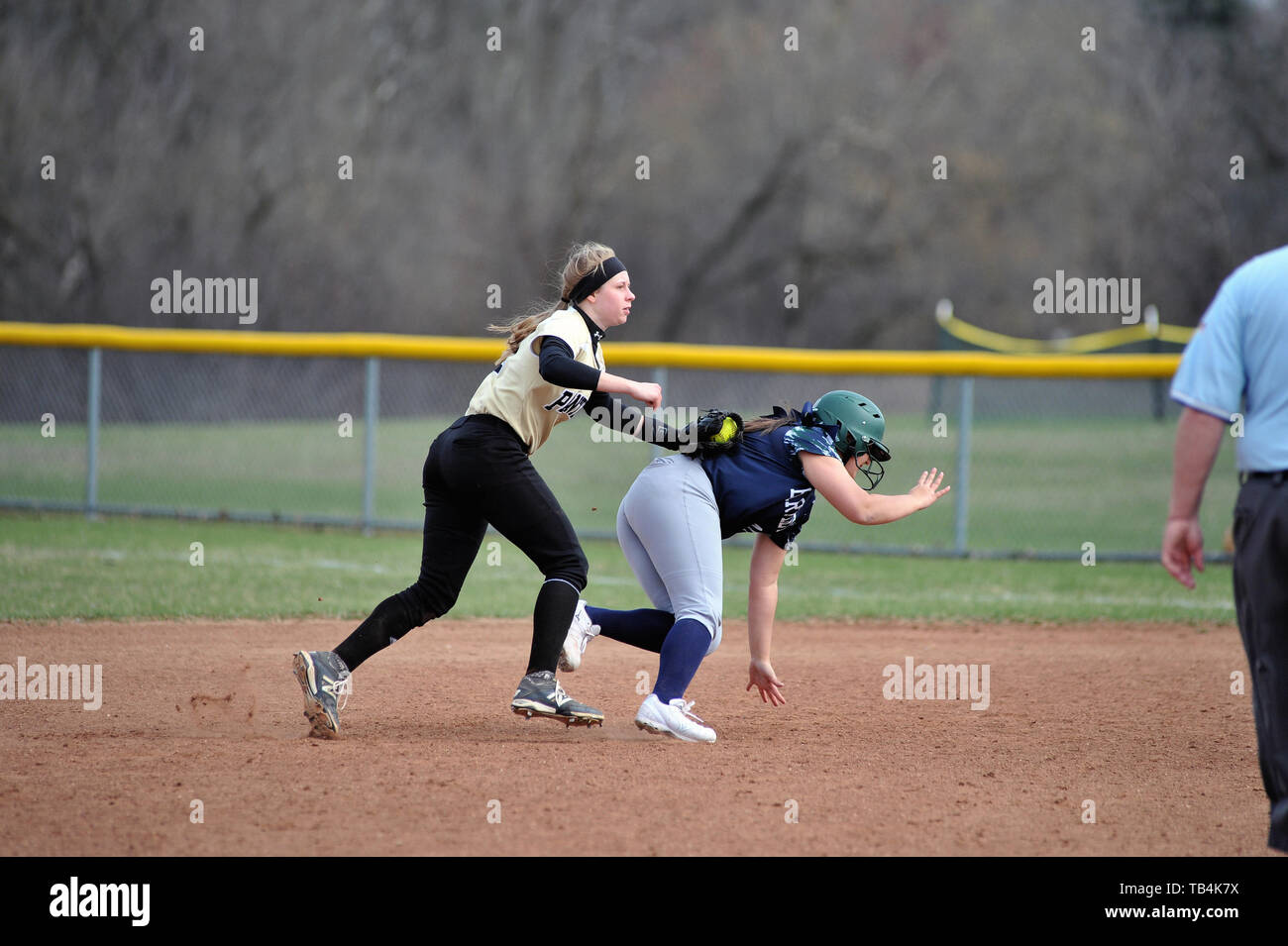 Infielder applying tag to a base runner that had been caught in a rundown play between first and second base. USA. Stock Photo