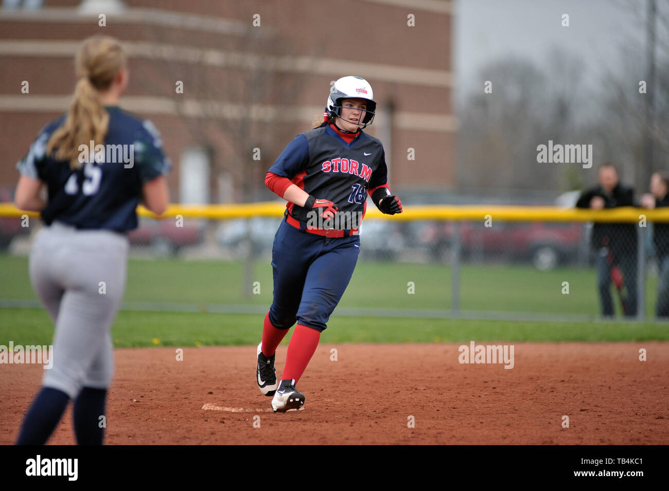 Batter rounding second base during her home run trot during a high school softball game. USA. Stock Photo