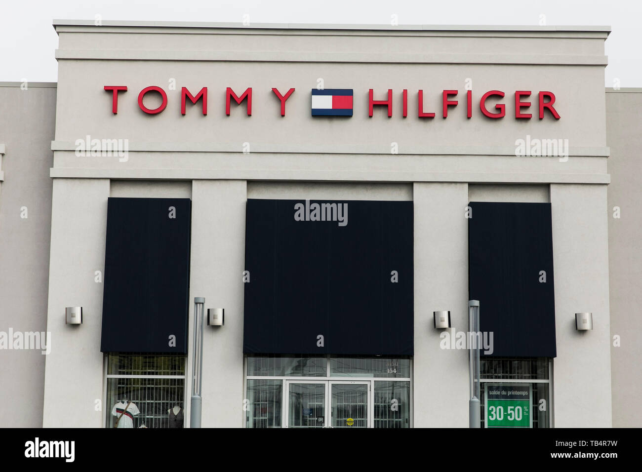 A logo sign outside of a Tommy Hilfiger retail store location in  Vaudreuil-Dorion, Quebec, Canada, on April 21, 2019 Stock Photo - Alamy