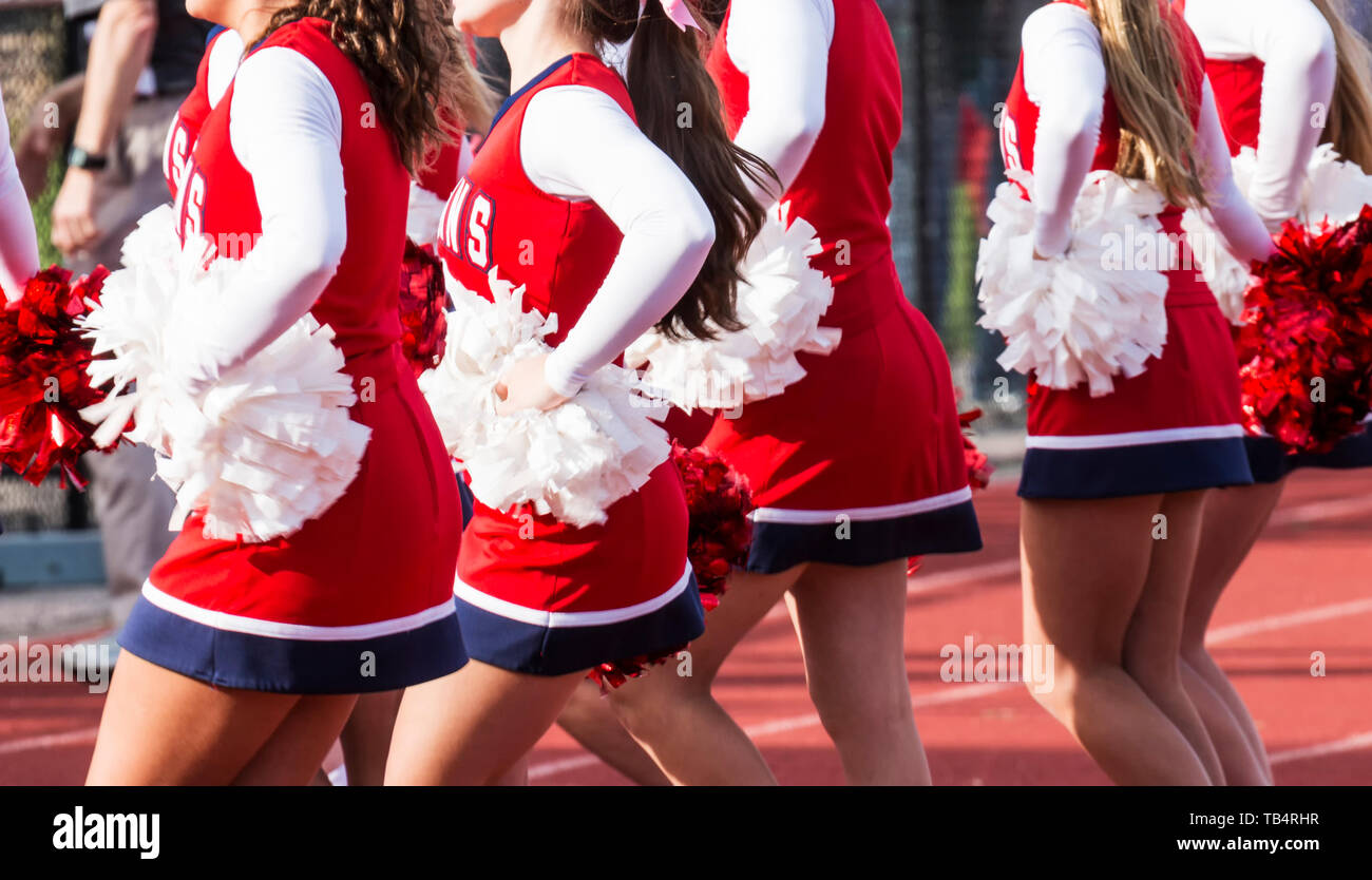 High school cheerleaders are cheering during a football game Stock