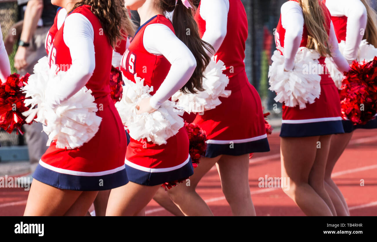 High school cheerleaders are cheering during a football game. Stock Photo