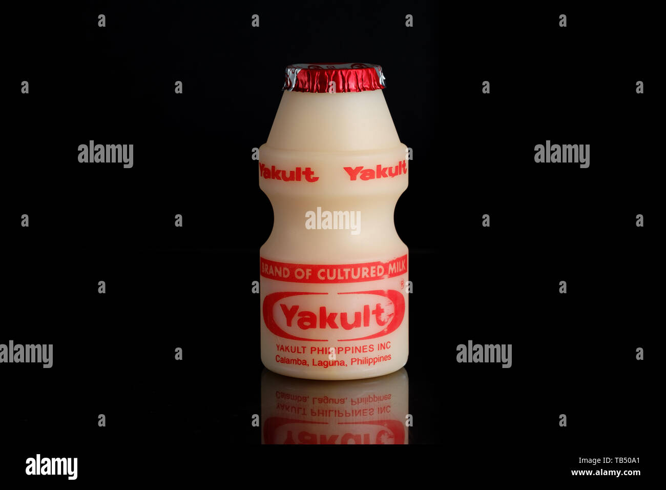 Yakult fermented milk drink on black isolated background Stock Photo