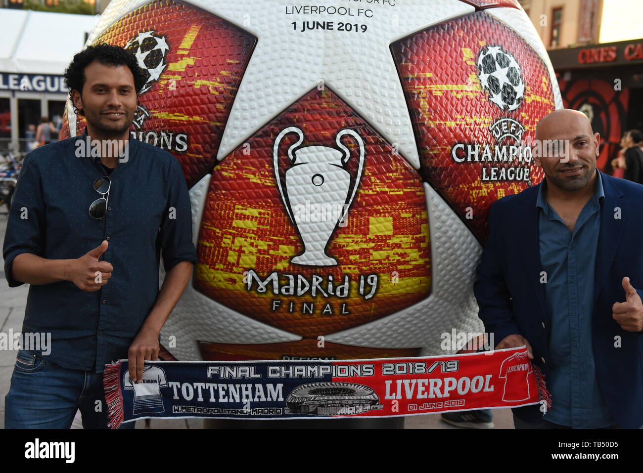 Two men are seen posing for a picture with an advertisement of the 2019 Champions League Final in Madrid. Madrid will host the UEFA Champions League final between Liverpool FC and Tottenham Hotspur on June 1, 2019 at the Wanda Metropolitano Stadium. Stock Photo