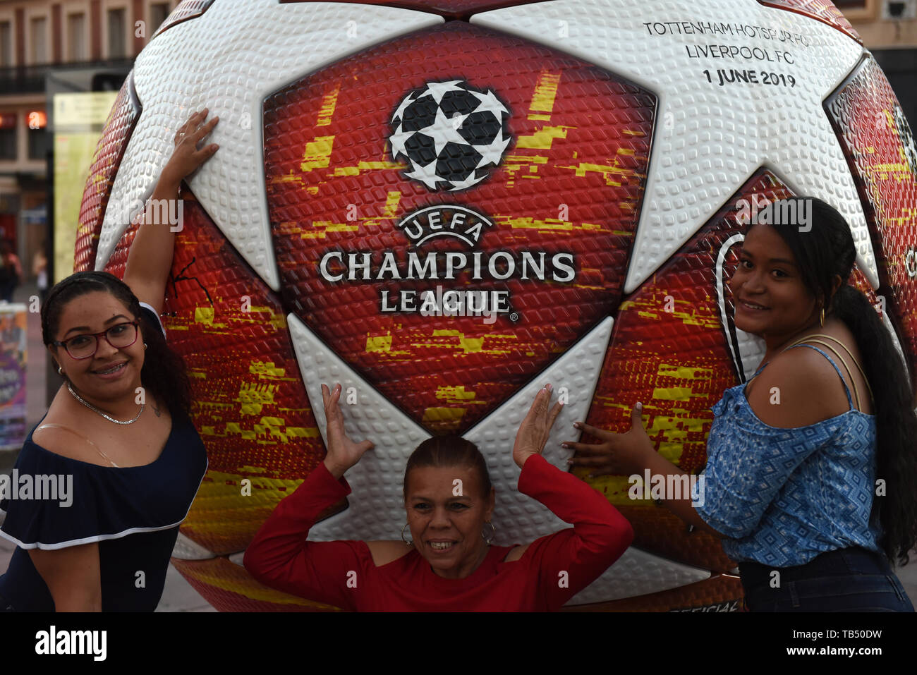 People are seen posing for a picture with an advertisement of the 2019 Champions League Final in Madrid. Madrid will host the UEFA Champions League final between Liverpool FC and Tottenham Hotspur on June 1, 2019 at the Wanda Metropolitano Stadium. Stock Photo