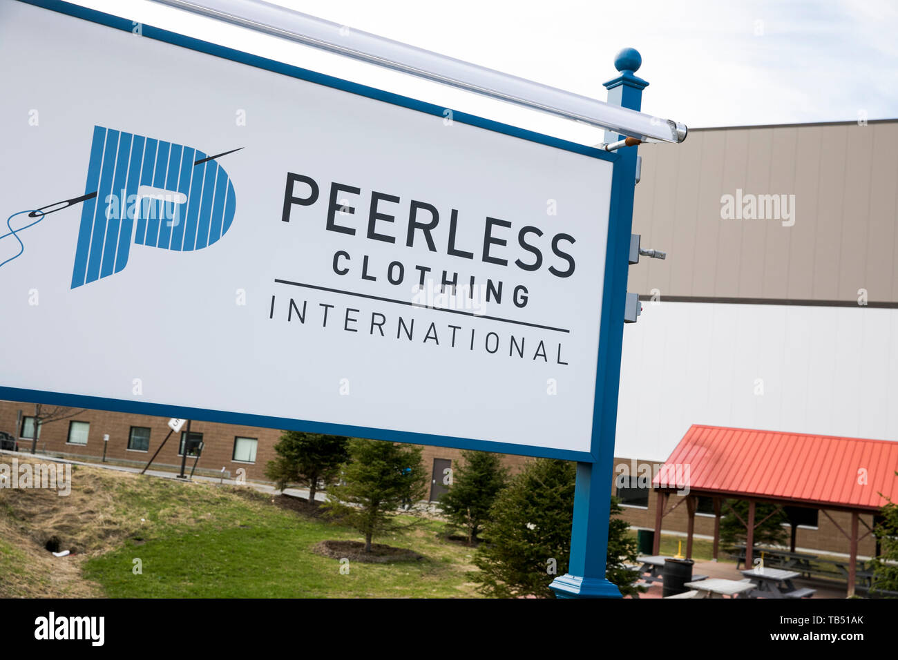 A logo sign outside of a facility occupied by Peerless Clothing in St Albans City, Vermont on