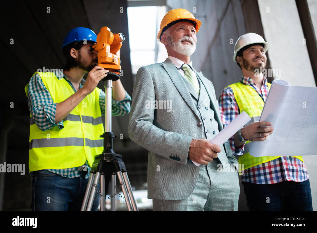 Engineer and construction site manager dealing with blueprints and ...