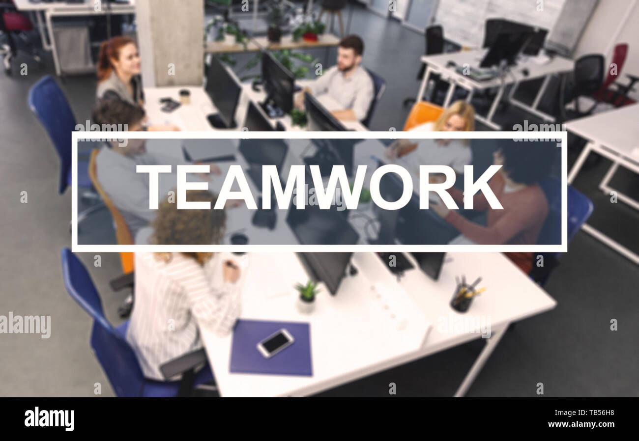 Teamwork inscription, young working people in modern office on ...