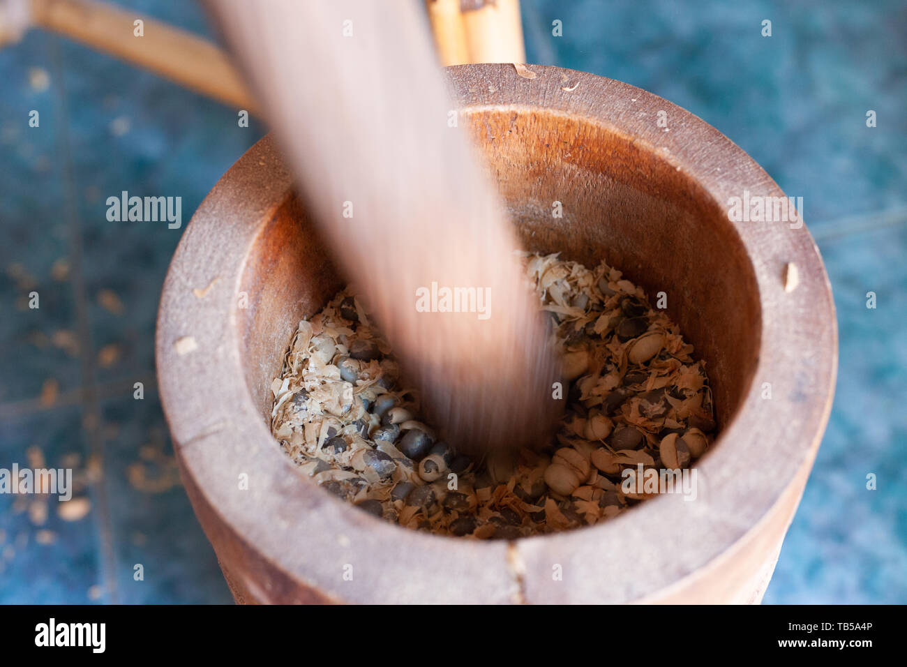 Using a mortar and pestle to remove shells (Cascara) from coffee beans