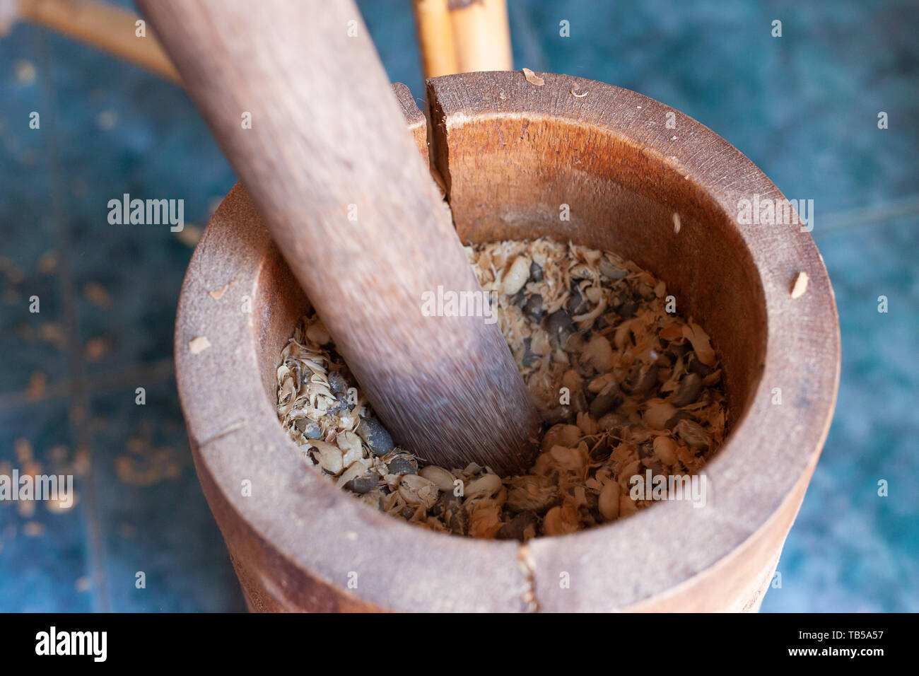Using a mortar and pestle to remove shells (Cascara) from coffee beans