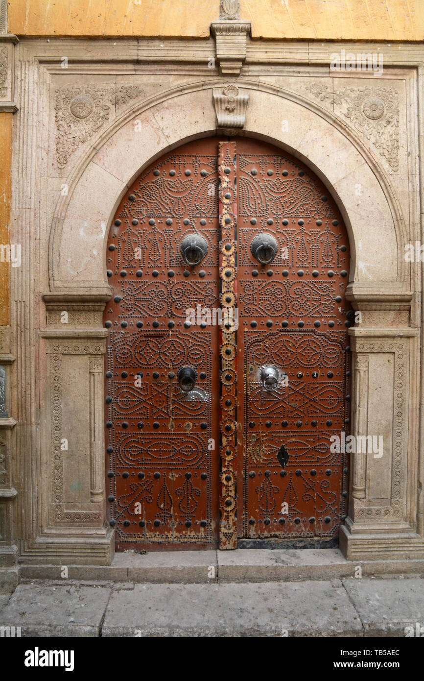 The traditional studded door of a 17th century house decorated with Islamic motifs in an alleyway of the medina (old city) of Tunis, Tunisia. Stock Photo