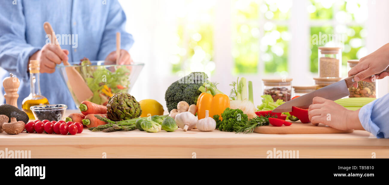 Cooking, food and home concept - close up of female hand cutting pepper on cutting board at home Stock Photo