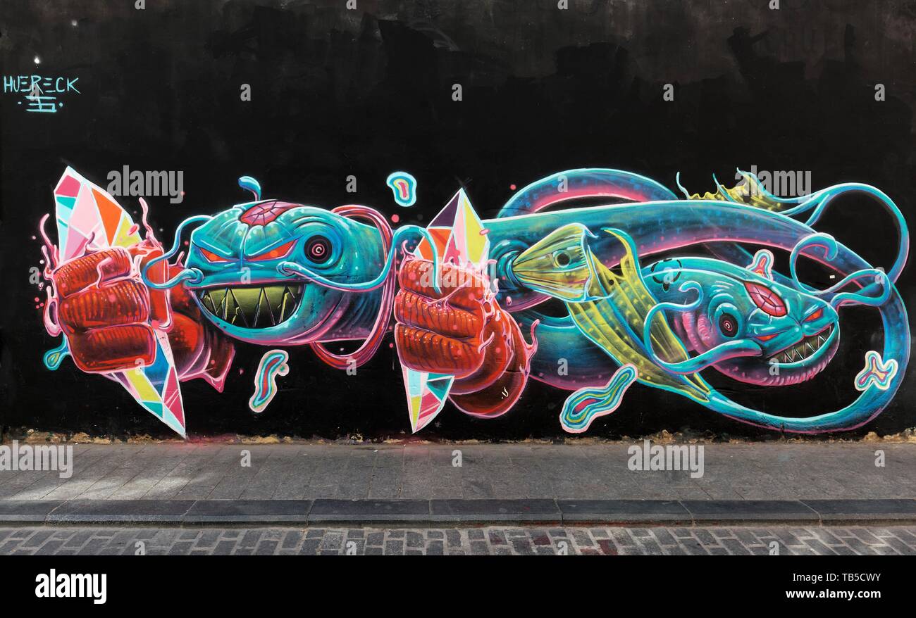Colorful sea monster with fists, graffito from Huereck, street art in the Carme district, old town, Valencia, Spain Stock Photo