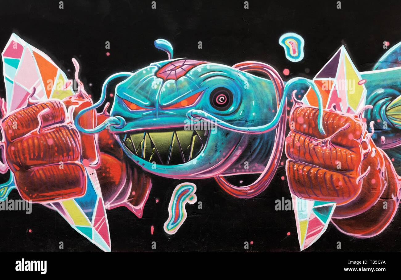 Colorful sea monster with fists, graffito from Huereck, street art in the Carme district, old town, Valencia, Spain Stock Photo
