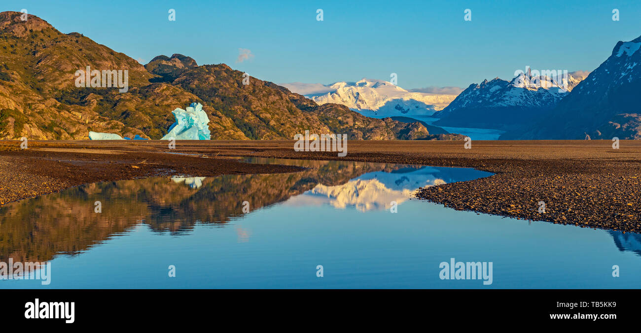 Panoramic sunrise by Lago Grey (Grey Lake) with a giant iceberg and Glacier Grey in the background, Torres del Paine national park, Patagonia, Chile. Stock Photo