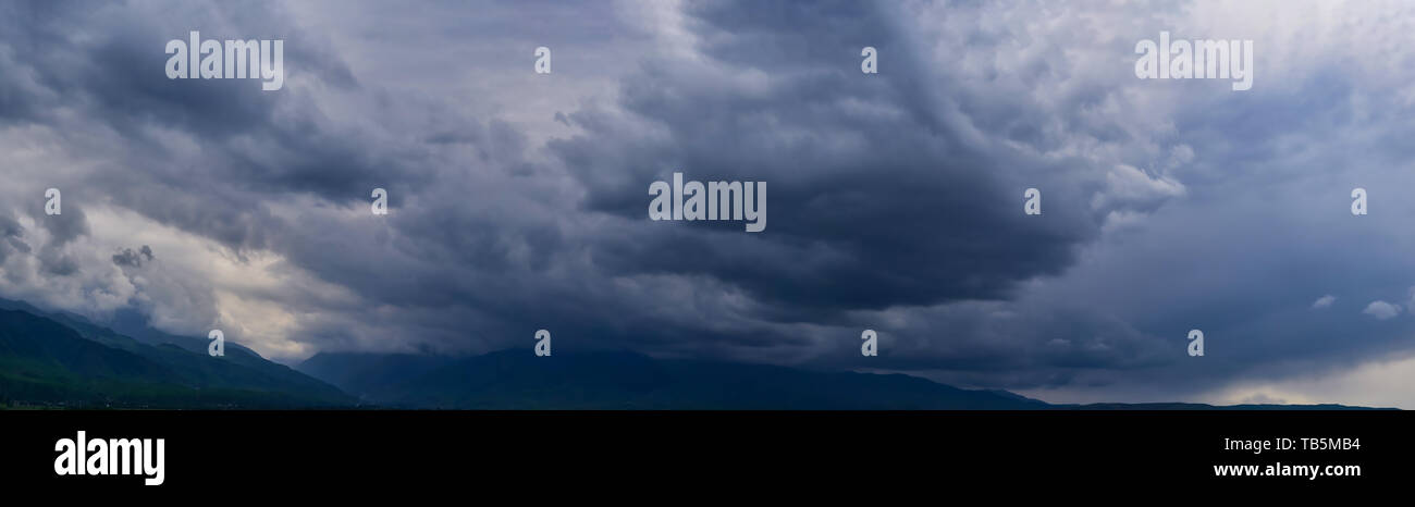 Valley with dramatic dark clouds and rain, storm clouds over the valley ...