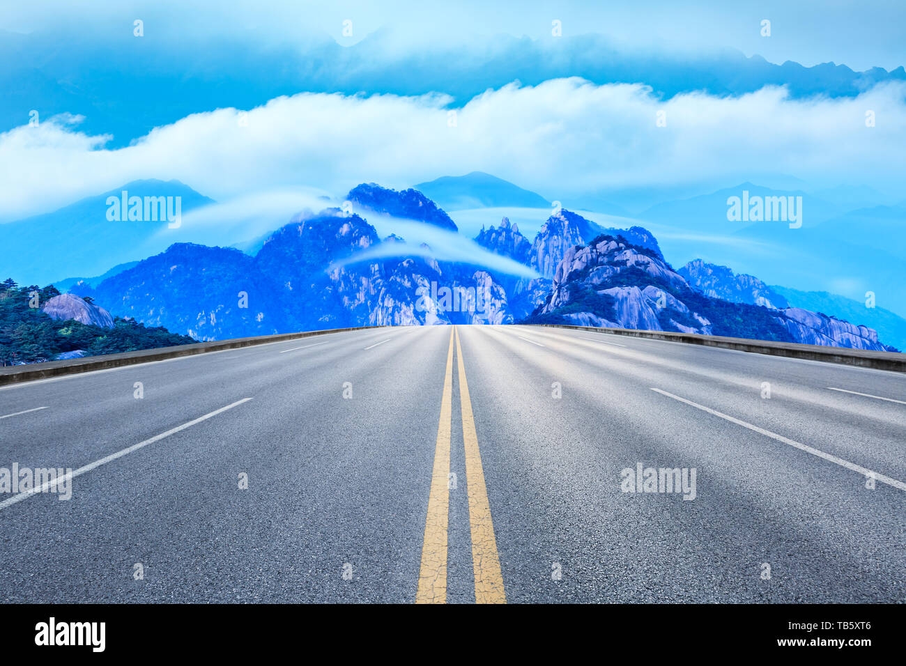 Straight asphalt road and beautiful huangshan mountains with clouds sea nature landscape Stock Photo