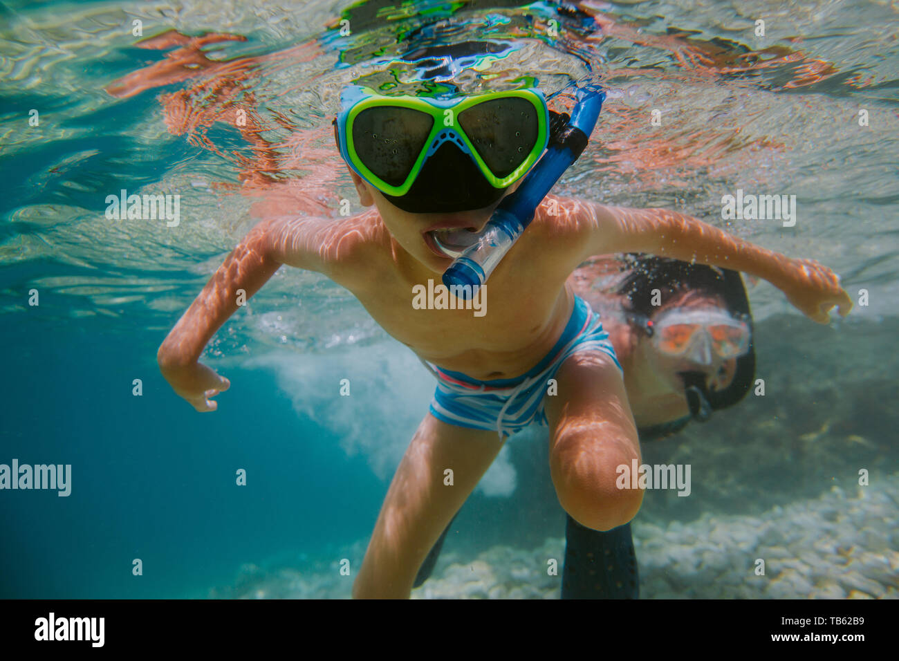 Child learning to snorkel with his mother in sea. Young boy wearing diving  mask swimming under water Stock Photo - Alamy