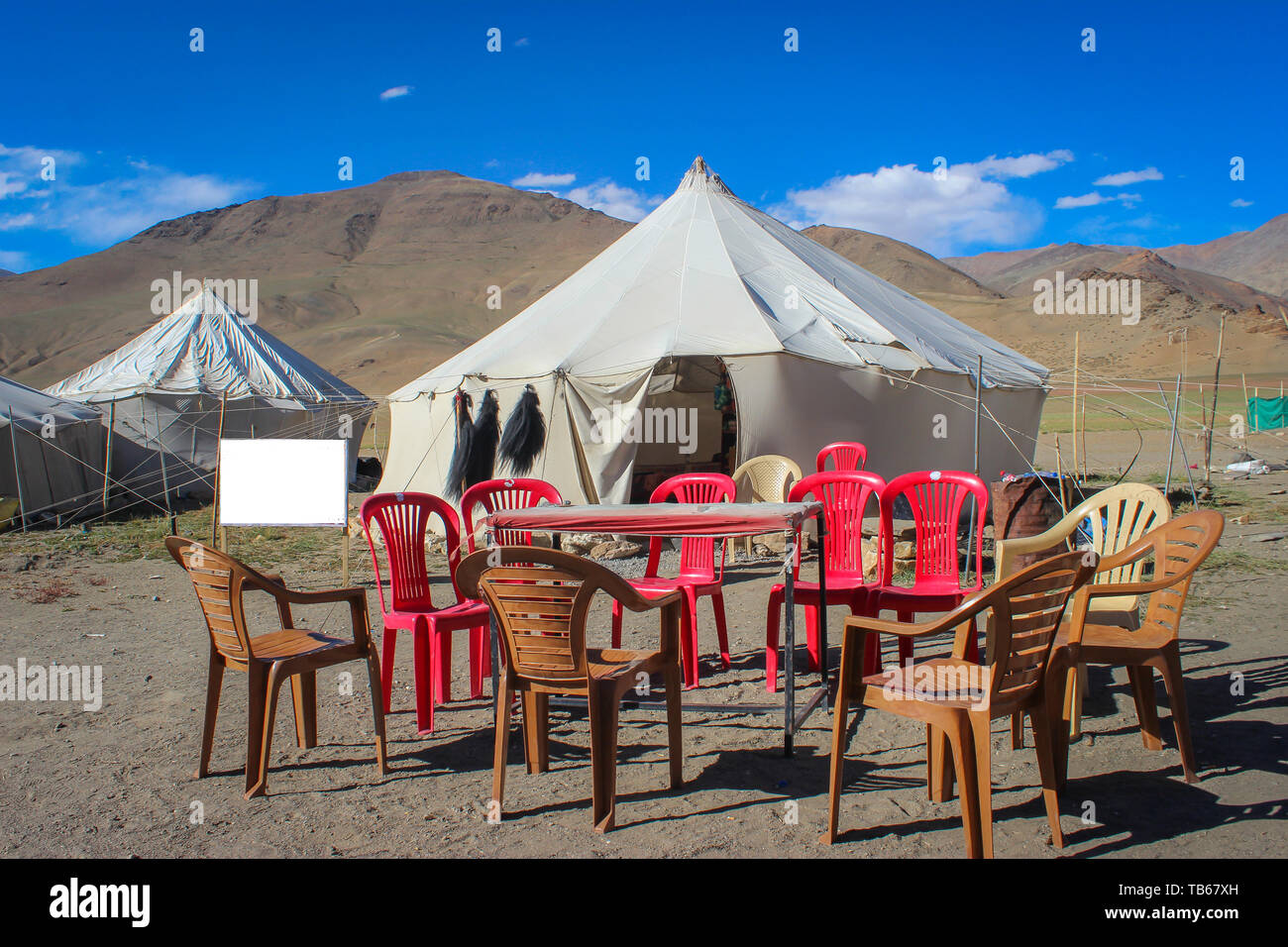 A small makeshift temporary tent restaurant in a desert in Ladakh. Plastic chairs and table kept outside the tent Stock Photo