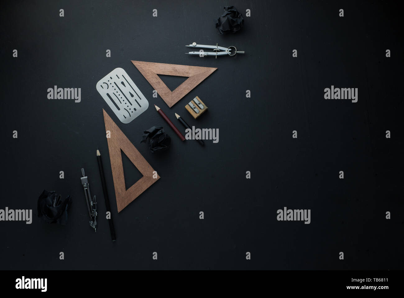 Drawing board flat lay with pencils, compasses, rulers and crumpled paper balls. The dark header for engineering, construction, and design with copy s Stock Photo