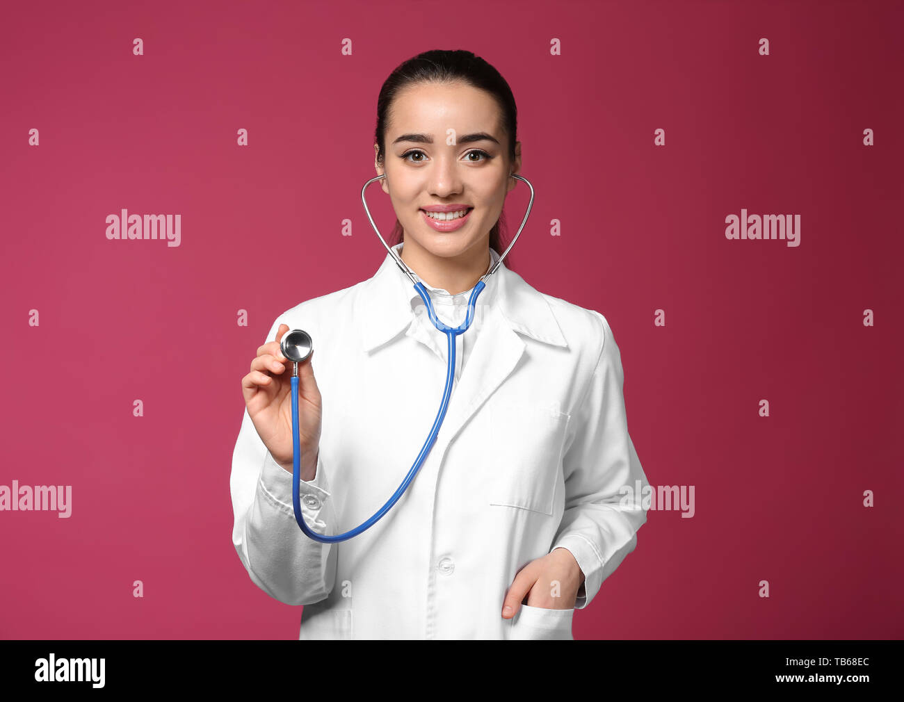 Female doctor using stethoscope on color background Stock Photo - Alamy