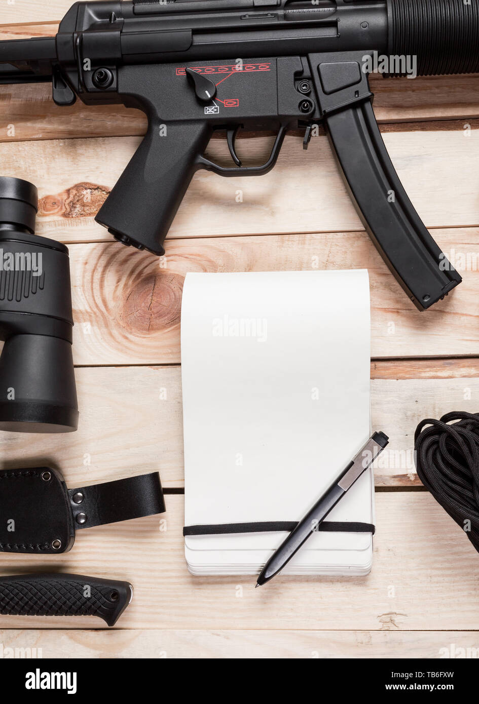 Assault rifle, gun, knife with sheath, compass and notebook with pen on ...
