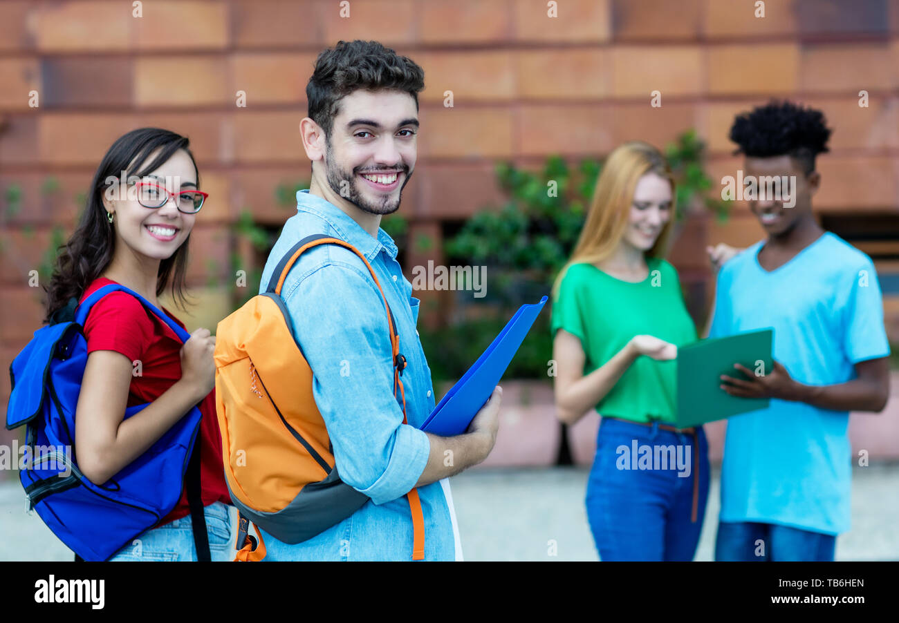 Laughing caucasian male and nerdy female student outdoors in summer Stock Photo