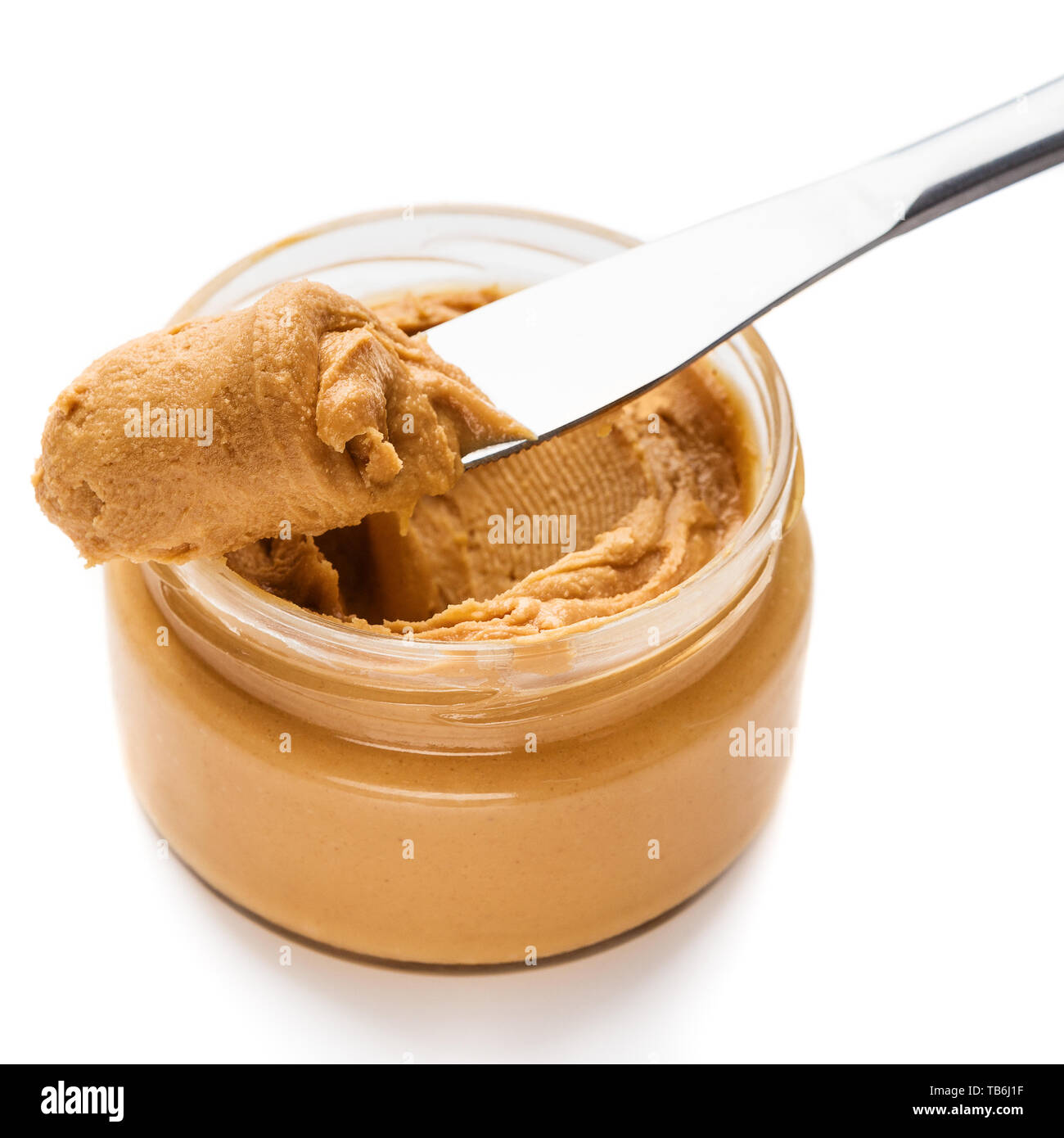 Jar and knife with creamy peanut butter on white background Stock Photo by  ©NewAfrica 193150800