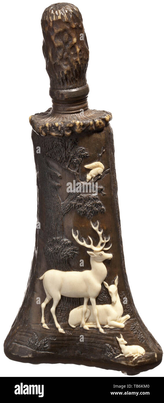 A carved staghorn powder flask, Thuringia, circa 1830/40, The body carved in one piece from a naturally grown stag horn, with an inset base. On the front, a fine carving of a majestic stag with doe and calf. A squirrel perched in the tree above the deer. Screw closure with a staghorn lid. Height 17 cm. Carvings of this type are generally attributed to the workshop of Leberecht Schulz, who worked in Meiningen and Thuringia. powder flask, accessory, accessories, military, militaria, object, objects, stills, utilities, utility, clipping, clippings, , Additional-Rights-Clearance-Info-Not-Available Stock Photo