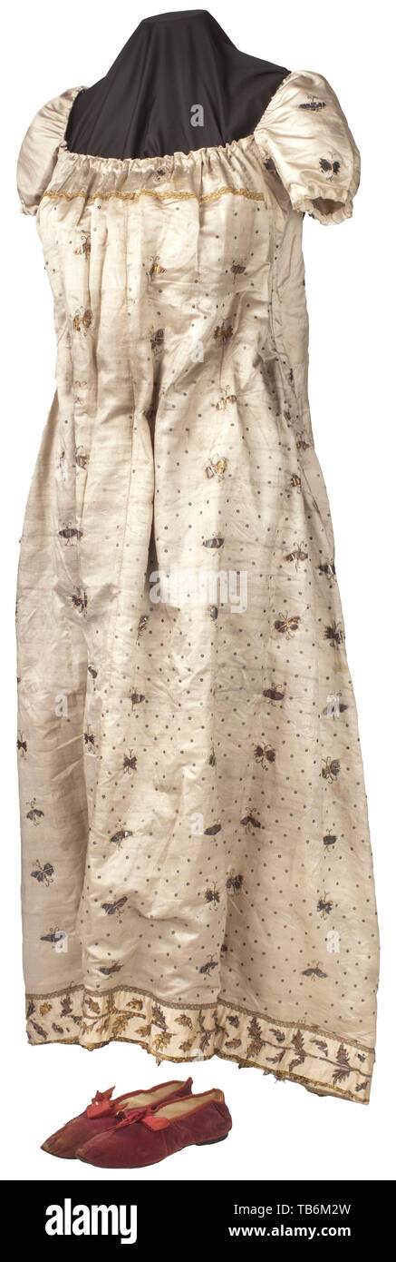 A light-coloured silk summer dress from the Murat family, Light-coloured silk with numerous applications in silver in the shape of butterflies and sequins, the cut corresponding to the Empire style or the transition to the Restoration period, the sleeves puffed at the sides, neckline and low back, the straps, edging and lower hem later additions, the dress with alterations, added accessories and some damage. Length 150 cm. Includes a pair of red velvet shoes. Provenance: Luisa Giulia 19th century, Additional-Rights-Clearance-Info-Not-Available Stock Photo
