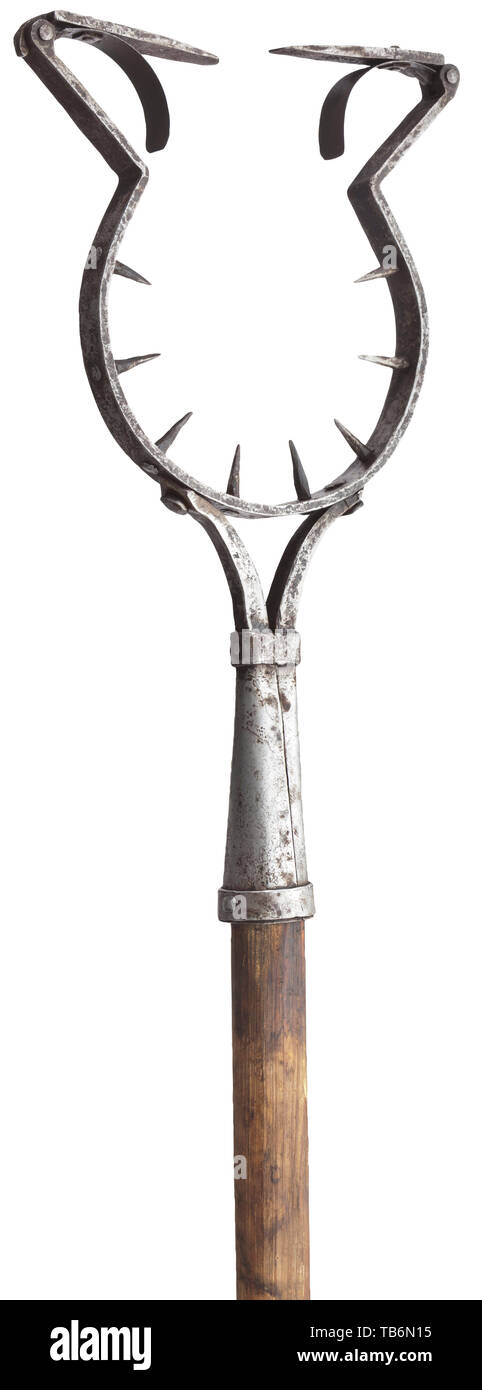 A German man catcher, 17th/18th century, Robust, wrought-iron shackle, with spikes protruding to the inside and two hinged, spring-loaded catches at the opening. Riveted, conical socket and plain, round wood staff. Length 210 cm. Rare device enabling to control prisoners at court, torture or before execution. This implement was attached to the neck of the handcuffed delinquent, who could thus be lead around as desired. instrument of torture, torture device, instruments of torture, torture devices, object, objects, stills, clipping, clippings, cut, Additional-Rights-Clearance-Info-Not-Available Stock Photo