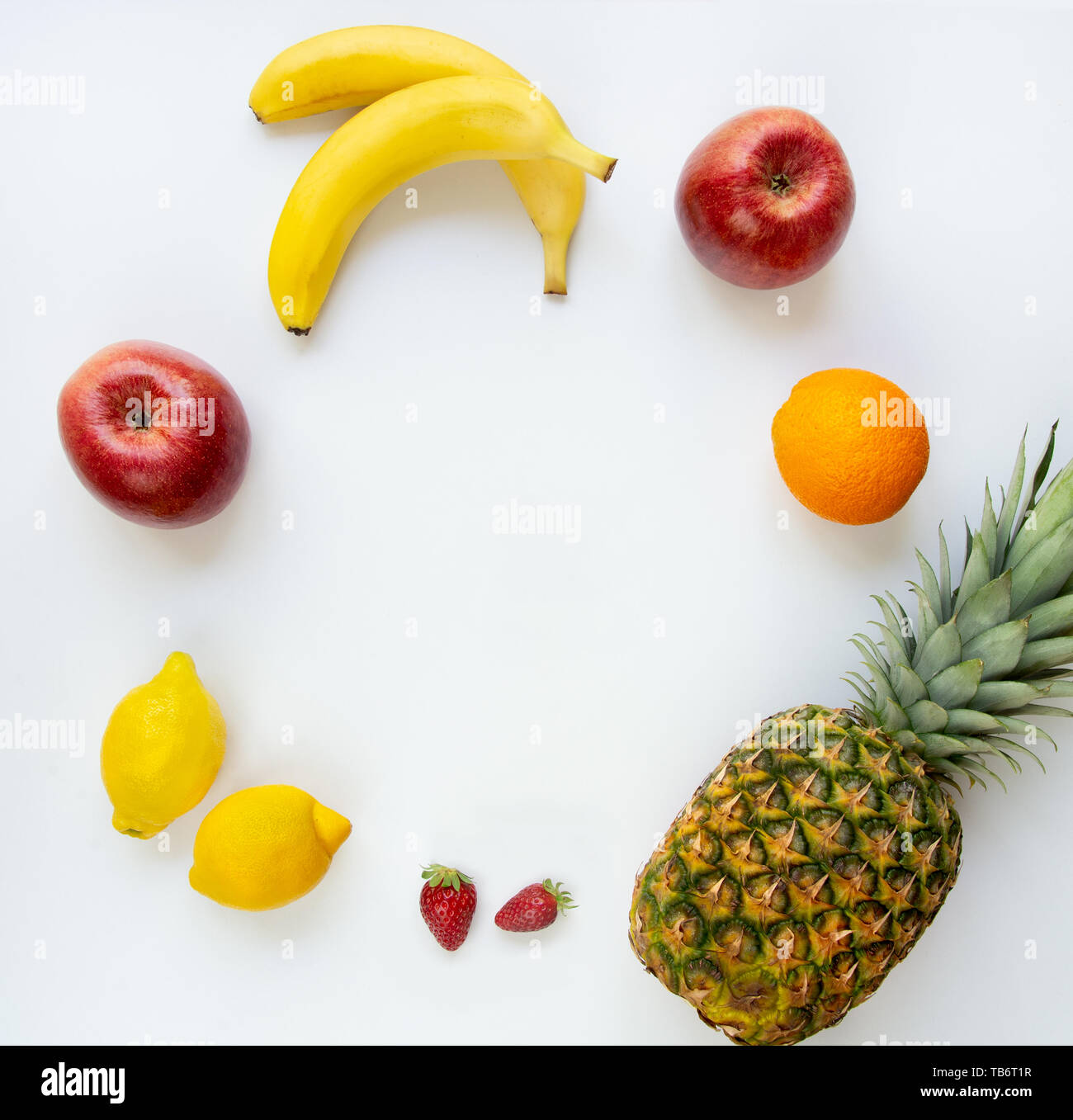 Top view of various fruits arranged in circle on a white background. Copy space. Stock Photo