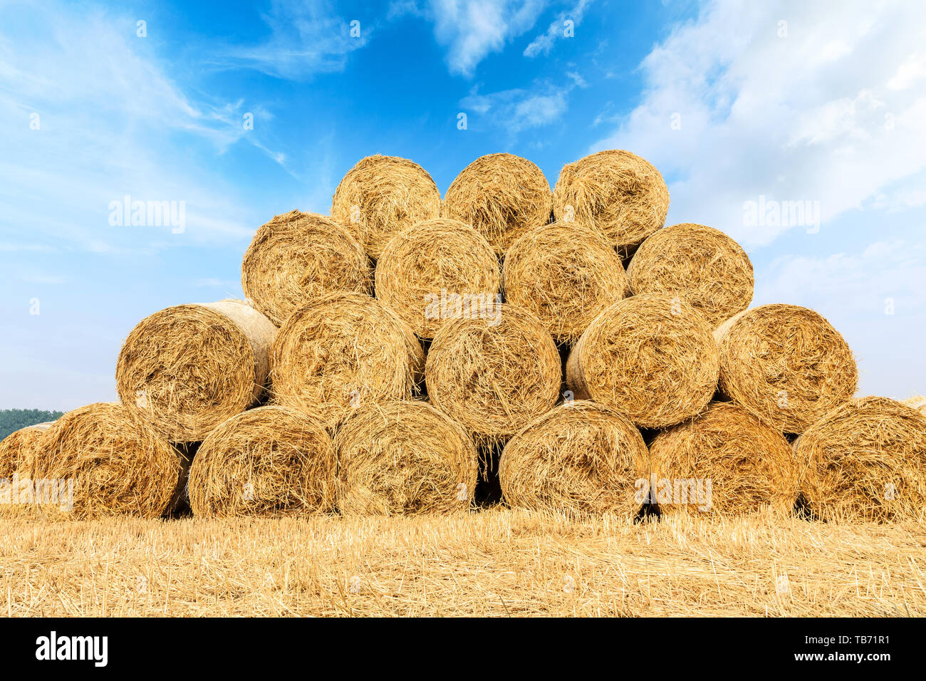 Straw bales on farmland with blue cloudy sky Stock Photo - Alamy