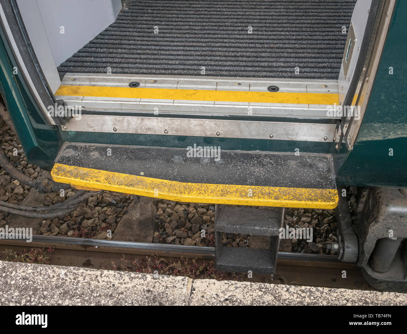 Gap between railway platform edge & GWS railway carriage step painted yellow. Metaphor Mind the Gap, watch your step, gender gap, wage gap, warning. Stock Photo