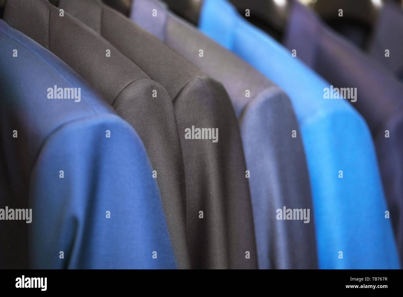 close up luxurious style gentlemen suit row, hanging in a closet . Stock Photo