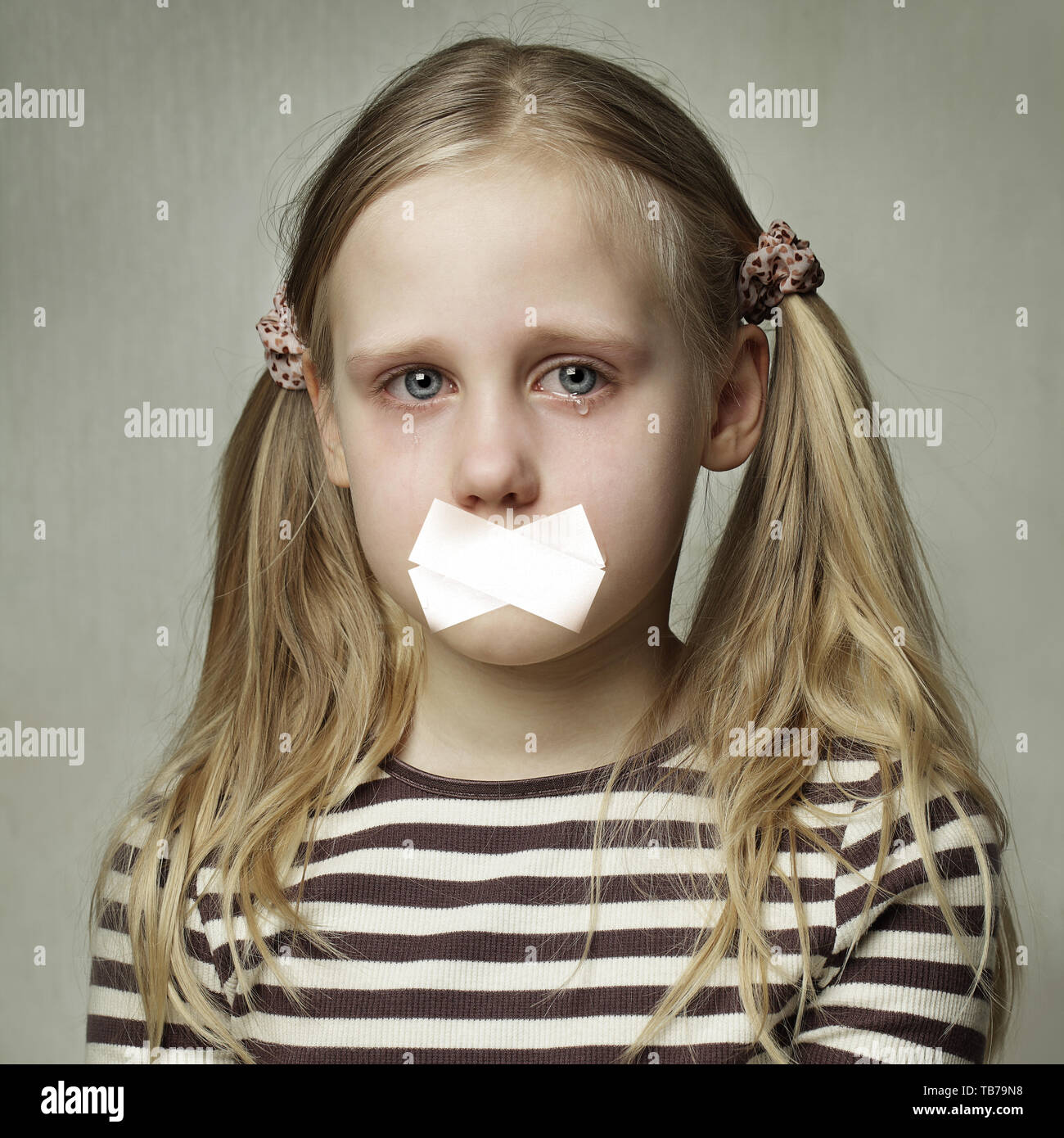 Sad Teenager With Sealed Mouth. Child with tears - young girl crying Stock Photo