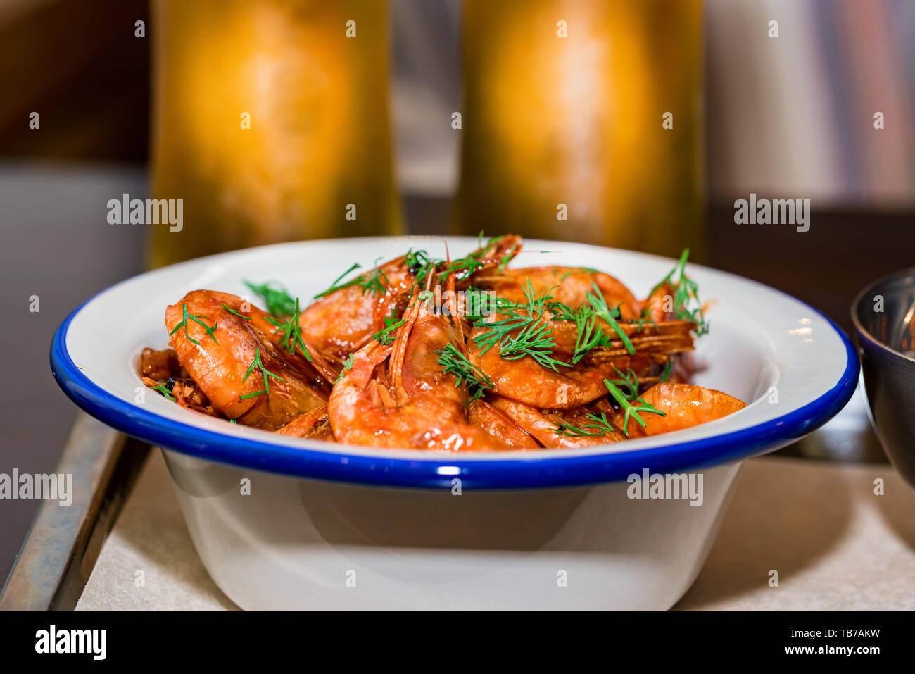 Prepared shrimps with dill in bowl on table with two beer glasses Stock Photo