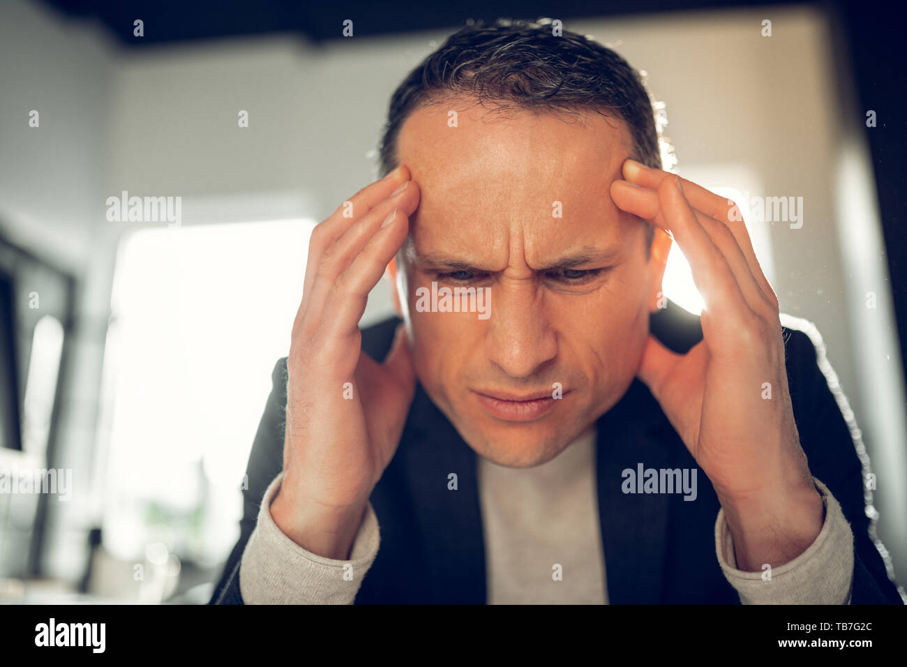 Businessman suffering from headache and high pressure Stock Photo