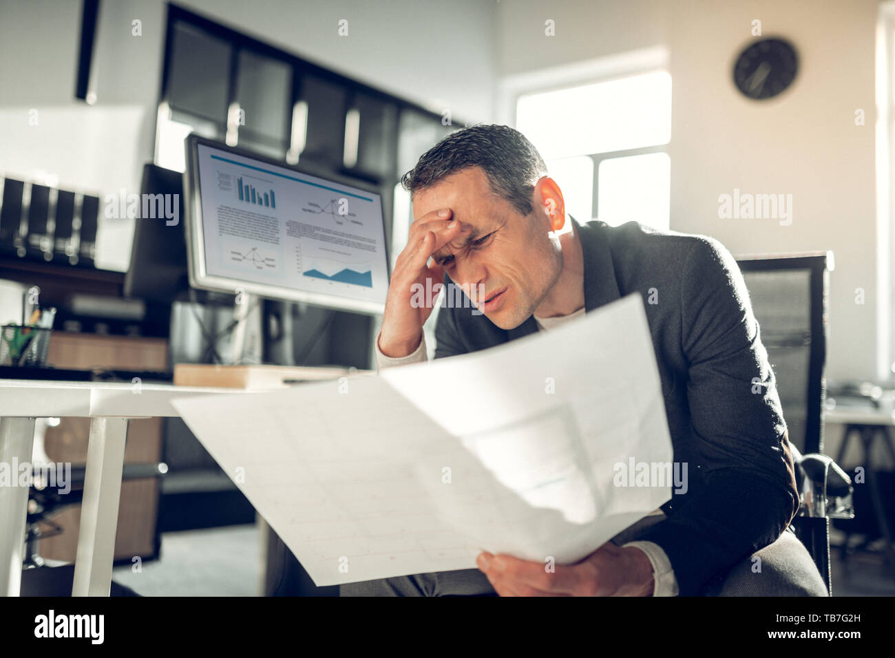 Darkhaired businessman suffering from headache after exhausting day