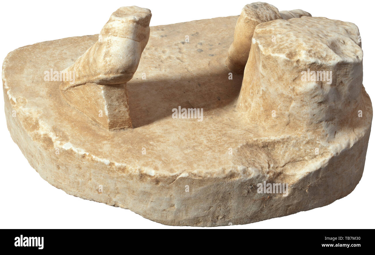 A Roman marble base with feet and tree stump of a statue of Apollo, 1st - 2nd century, Base plate of 7 cm height, the lateral surfaces straight at the front with two rectangular connecting holes and rounded at the back. On the base two sandal-clad feet of a figure striding to the left in front of a tree stump, their posture corresponding to a Roman copy reminding of the statue of Apollo (Apollo Belvedere) attributed to the Hellenistic sculptor Leochares. Minimal attritions and knocks on the surface. Width 39 cm, height 22 cm. Provenance: Polish p, Additional-Rights-Clearance-Info-Not-Available Stock Photo
