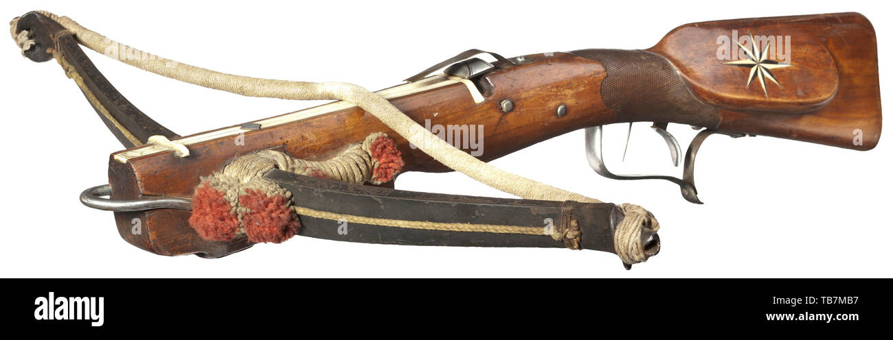 A Saxon sport crossbow with gaffle, circa 1830, Heavy iron prod with a later hemp string and original decorative woollen tassels. The inside of the bow embellished with floral ornaments. The original bridle of cord with tassels made of wool pompoms. The walnut tiller with quarrel groove and overlay of bone. Iron nut with brass bolt clip. Set trigger, iron finger rests. On the cheek an inlaid compass rose made from black horn and bone. Also, the corresponding wooden gaffle inlaid with a monogram plaque 'SGF' in bone. Length 80 cm. A typically heav, Additional-Rights-Clearance-Info-Not-Available Stock Photo