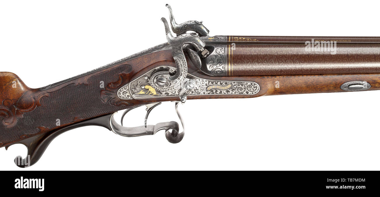 A deluxe percussion double-barrelled shotgun, G. and F. Spicker, circa 1850, The browned Damascus barrels in 17.5 mm calibre, the bores slightly rough. The patent breechblock and tang engraved with decorative tendrils and gold-inlaid animals. The barrel rib stamped 'DAM:BERNARD.' En suite decorated percussion locks with chiselled hunting scenes of game and hounds, also inlaid in 19th century, Additional-Rights-Clearance-Info-Not-Available Stock Photo