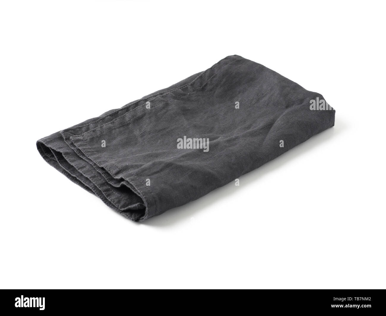 Side view on folded dark black linen napkin isolated on white background. Anthracite grey linen napkin. Isolated on white with clipping path. Stock Photo